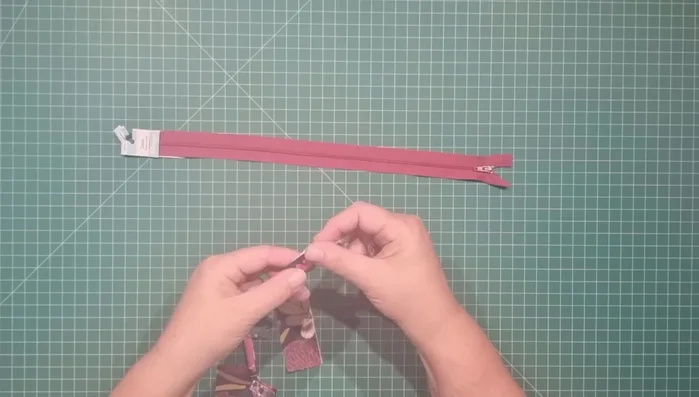 Make handle and zipper tabs: Fold handle strip in half lengthwise, fold raw edges in, fold in half again, and stitch down both long edges. Prepare zipper tabs similarly.