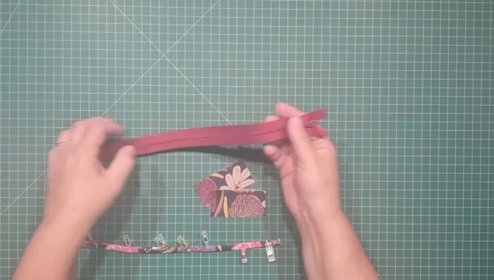Prepare the zipper: Cut off excess zipper tape from both ends, leaving the metal pull tabs. Attach zipper tabs to zipper ends, placing fabric right sides together and securing with clips, then stitch.