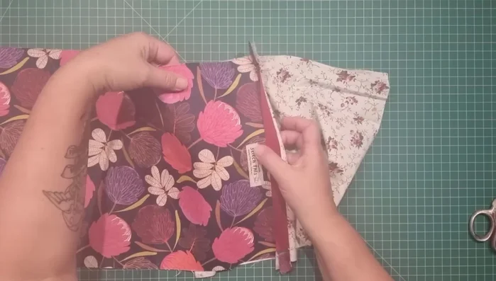 Top stitch zipper: Top stitch along the top edge of the zipper, attaching outer fabric and lining, only stitching from side seam to side seam on the outer fabric side. Avoid stitching over zipper tabs. Repeat on both sides.