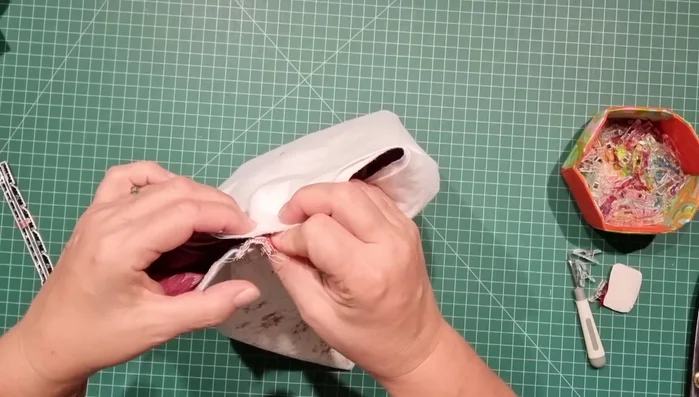 Clip and sew sides: Mark center point on both main fabric and lining. Clip lining and main fabric at center points to match zip. Fold outer fabric edges up 2 inches on both sides; repeat with lining. Stitch down the sides, leaving openings at zipper ends.