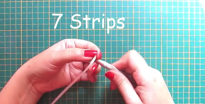 Create hands and nose: Make leaf shapes with white strips for the hands and a cone with orange strip for the nose.