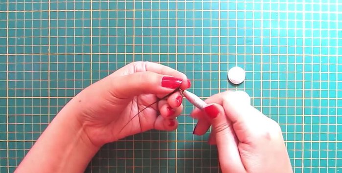 Create hands and nose: Make leaf shapes with white strips for the hands and a cone with orange strip for the nose.