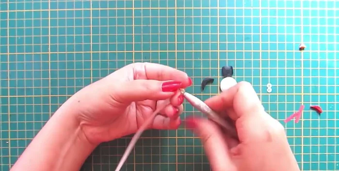 Create hands and nose: Make leaf shapes with white strips for the hands and a cone with orange strip for the nose.