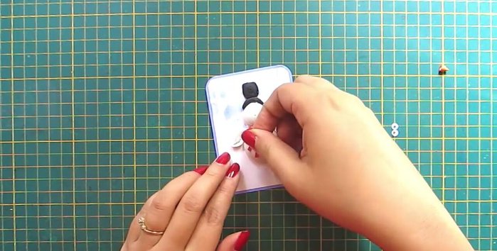 Add finishing touches: Add a scarf and write 'Merry Christmas'. Attach a ribbon.