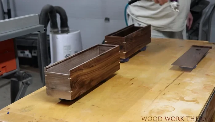 Use planer shavings to create a decorative and protective bed for the wine bottle inside the box.