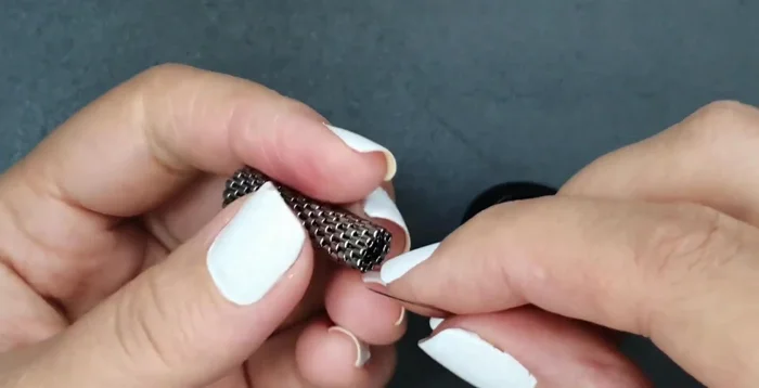 Attach the ring to the earring using seed beads. Secure with knots and trim excess thread.