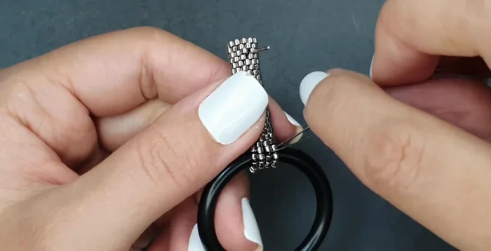 Reinforce the attachment of the ring by going through all the seed beads multiple times.