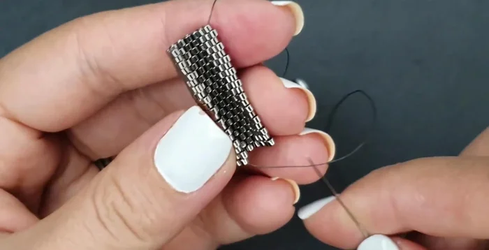 Attach the earring pin, going through the seed beads on both sides of the folded work, securing the pin.