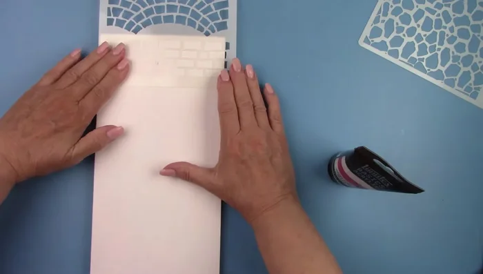 Spray stencils with adhesive.