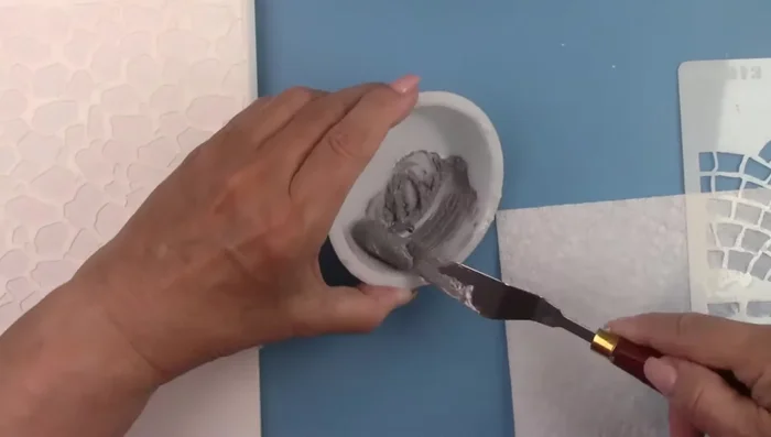 Mix gray paint with texture paste (or any desired color) and spread over the stencil.