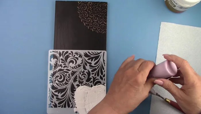 Add paint to some of the crackle paste and spread it over the stencil.