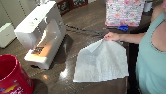 Cut neck hole on towel: Fold the towel in half to ensure evenness. Pin and cut out the neck hole using the circle pattern, positioning it 1-2 inches below the top edge.