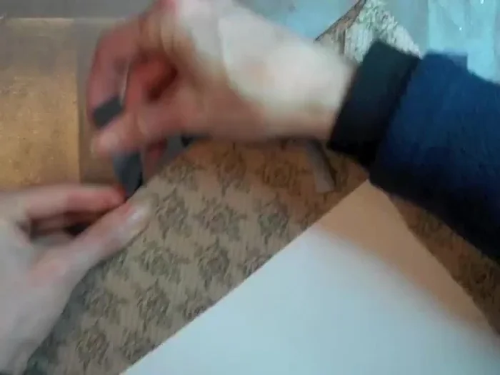 Glue the ribbon to the board, pulling taut.