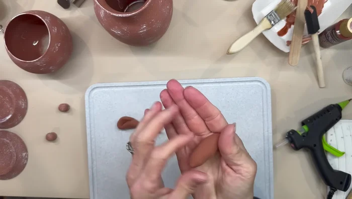 Attach the clay handles to the vases and let them dry before gluing them with E6000 glue. Paint the handles to match.