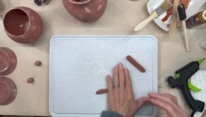 Attach the clay handles to the vases and let them dry before gluing them with E6000 glue. Paint the handles to match.