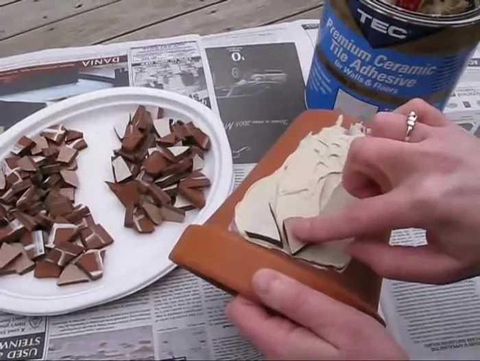 Set the tile pieces into the adhesive like a jigsaw puzzle.