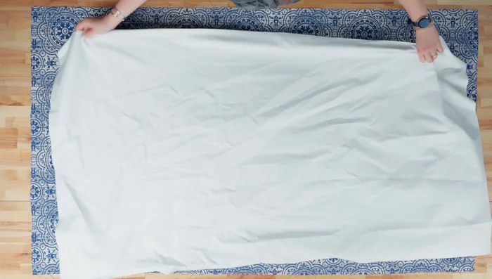 Layer one fabric panel (wrong side up) and one blackout liner panel (right side up) in the middle. Pin the layers together (clips won't reach).