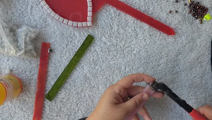Cut and shape larger stained glass tiles into daisy shapes for the ladybug's body.