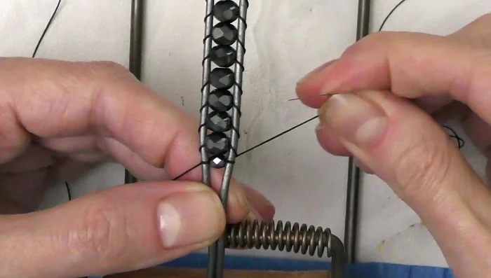 Tie off the thread using a preferred method (described in the video). Trim excess thread and secure with glue.