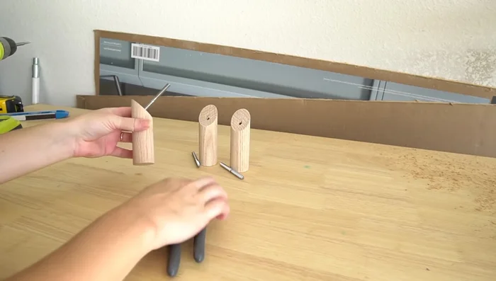 Twist the pointy end of the hanger bolt into the wood hook using pliers, as far as possible without going through.