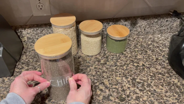 Slowly peel away the transfer tape, leaving the vinyl labels adhered to the canisters.