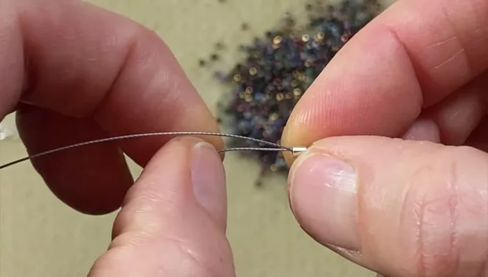 Crimp the bead: Crimp the bead tightly using crimping pliers to secure it. Trim any excess wire with flush cutters and smooth out any sharp edges.