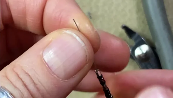 Finish the necklace: Add a crimp bead to the other end, leaving a small tail for threading through the clasp. Crimp the bead and trim the excess wire, ensuring the crimp is smooth.