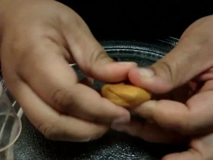 Use the baked clay grid as a stamp, pressing it gently into the colored clay to create the ice cream cone pattern. Use a small amount of oil to prevent sticking if needed.