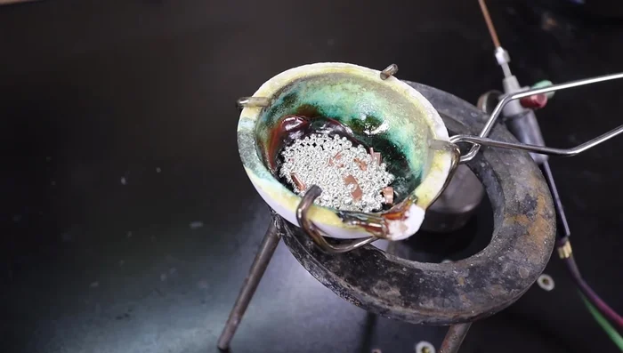 Add Flux: Sprinkle a small amount of borax (flux) into the crucible. This helps with melting and prevents impurities.