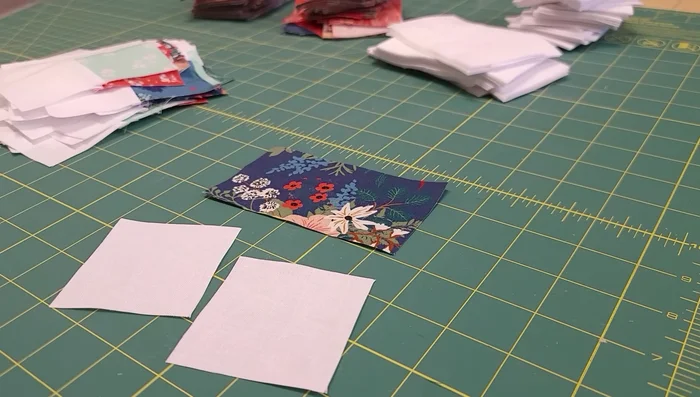 Create the flying geese units. Draw diagonal lines on the light squares, stitch along the lines, and press seams carefully according to instructions given in the video to minimize bulk and create sharp points.