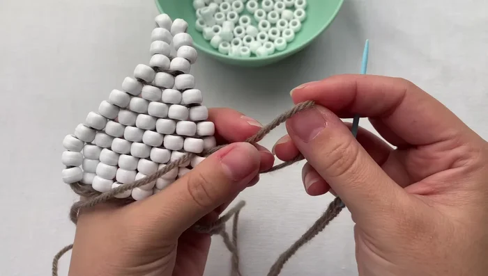 Tie a double knot to secure the loop. Grab the loop, thread your needle through once, wrap around, and pull tight.