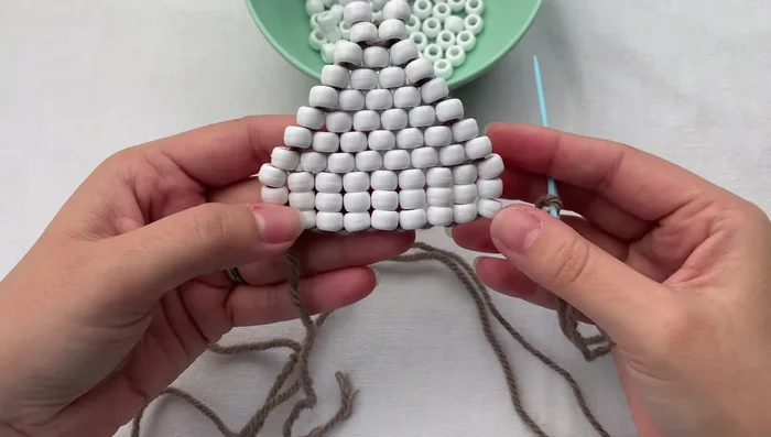 Tie a double knot to secure the loop. Grab the loop, thread your needle through once, wrap around, and pull tight.