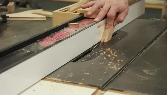 Cut the spline using the table saw blade thickness as a reference, referencing the outside face of the frame against the fence.