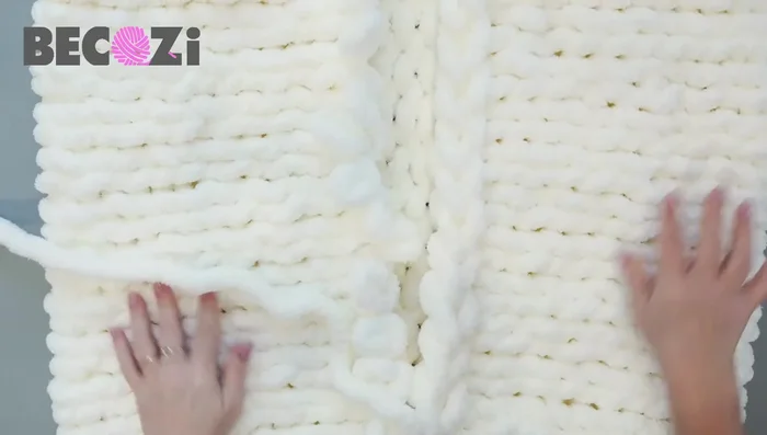 Connecting the two sides: Don't cast off. Lay the knitted piece flat, aligning the beginning and end stitches. Using the working yarn and the tail, sew the two sides together with a simple stitch, working through the cast-on edge and the last row's stitches.