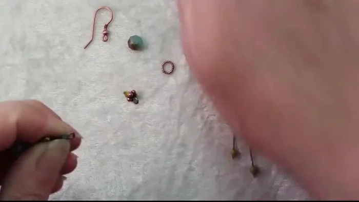 Attach the ear wire: Open the loop of the ear wire and slide it onto the earring assembly (177.88).
