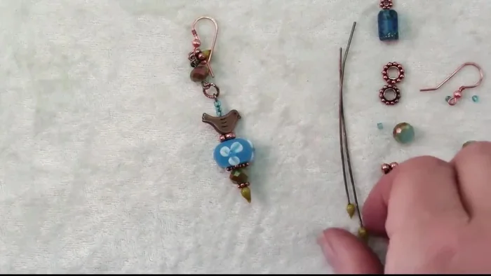 Repeat steps 3-5 for the second earring, adapting the design for asymmetry and balance. Be prepared to improvise and adjust based on material availability and practicality (213.13).