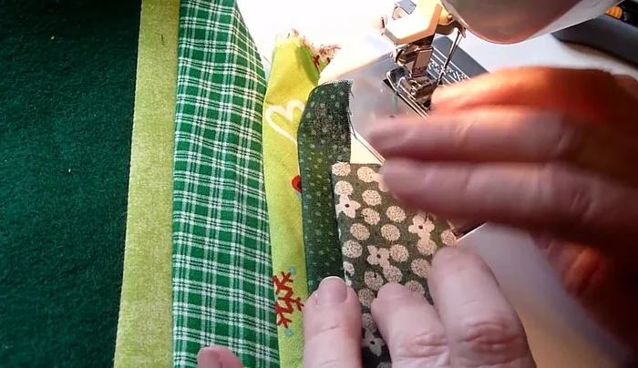 Complete the patchwork: Continue adding fabric strips until you reach the corner. Fold and flip the last piece to create a seamless edge.