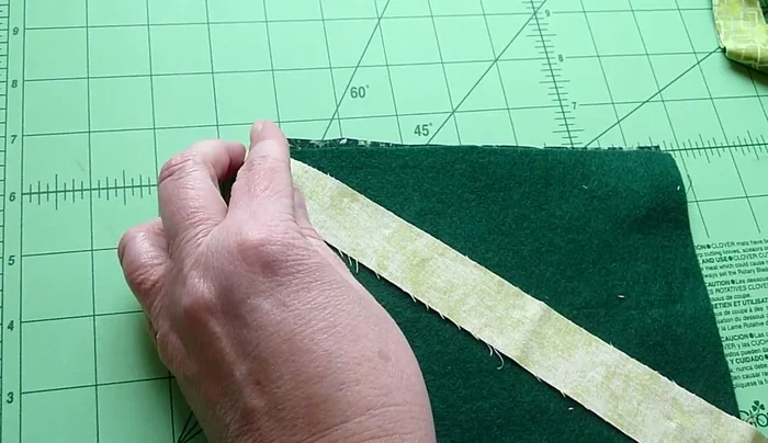 Complete the patchwork: Continue adding fabric strips until you reach the corner. Fold and flip the last piece to create a seamless edge.