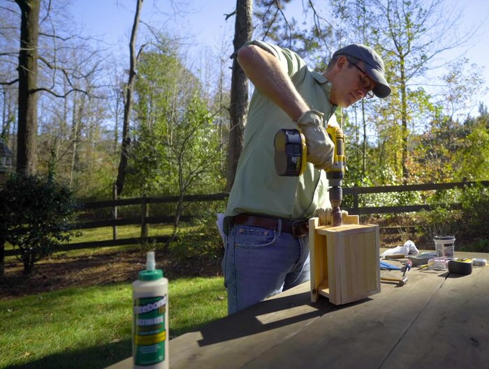 Apply wood glue and tap the dowel rod (perch) into the smaller holes. Wipe away excess glue.