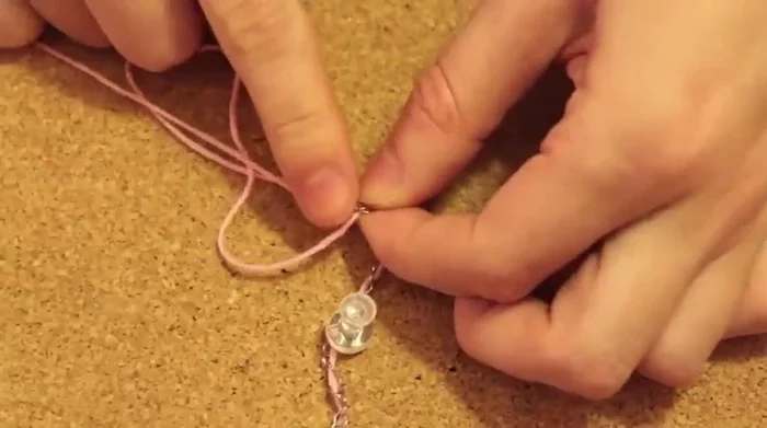 Tie another knot at the end to secure the floss.