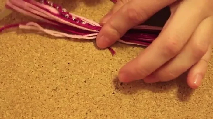 Tie a knot to secure the tassel to the necklace at the longer end, and repeat for the other end.