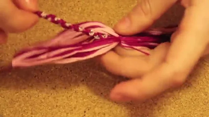 Tie a knot to secure the tassel to the necklace at the longer end, and repeat for the other end.
