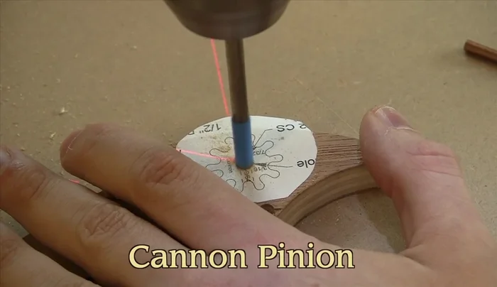 Drill holes and countersinks for the cannon pinion, ensuring concentricity.