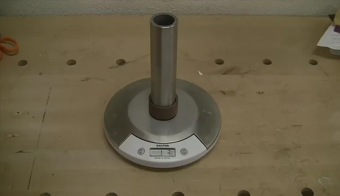Make the clock weight from a steel tube filled with lead shot and capped with walnut.