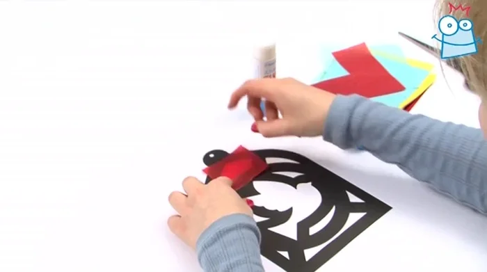 Apply glue around the edge of a shape and press the tissue paper onto it. Repeat for all shapes, ensuring the tissue paper covers the shape completely.