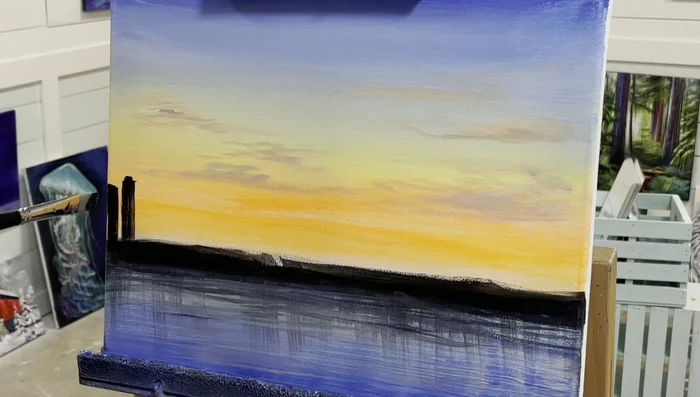 Paint the buildings using a flat brush with black paint. Leave small spaces to simulate windows and lights. Use the flat edge for straight lines and turn the brush sideways for thinner buildings.