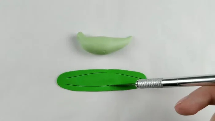 Add dark green clay for the belly, cutting and shaping it to fit the body. Add scales using a blade or flat edge tool and liquid Sculpey.