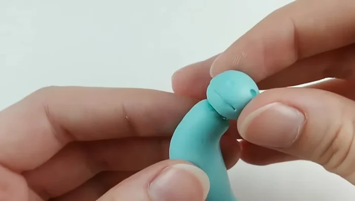 Attach the head to the body, blending with an angled silicone tool. Add eyes.