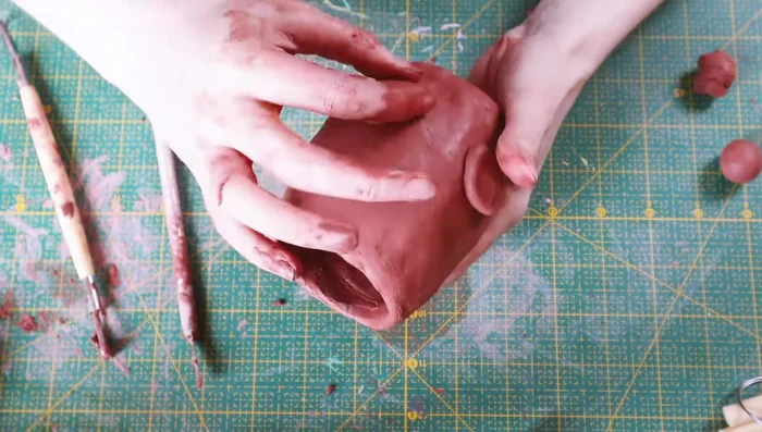 Add arms by shaping small pieces of clay, scoring contact points, and blending.