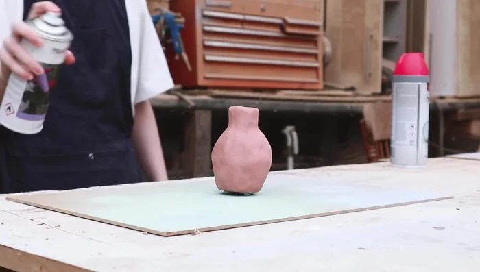 Paint faces on the vase using acrylic paint and add details with Posca pens.